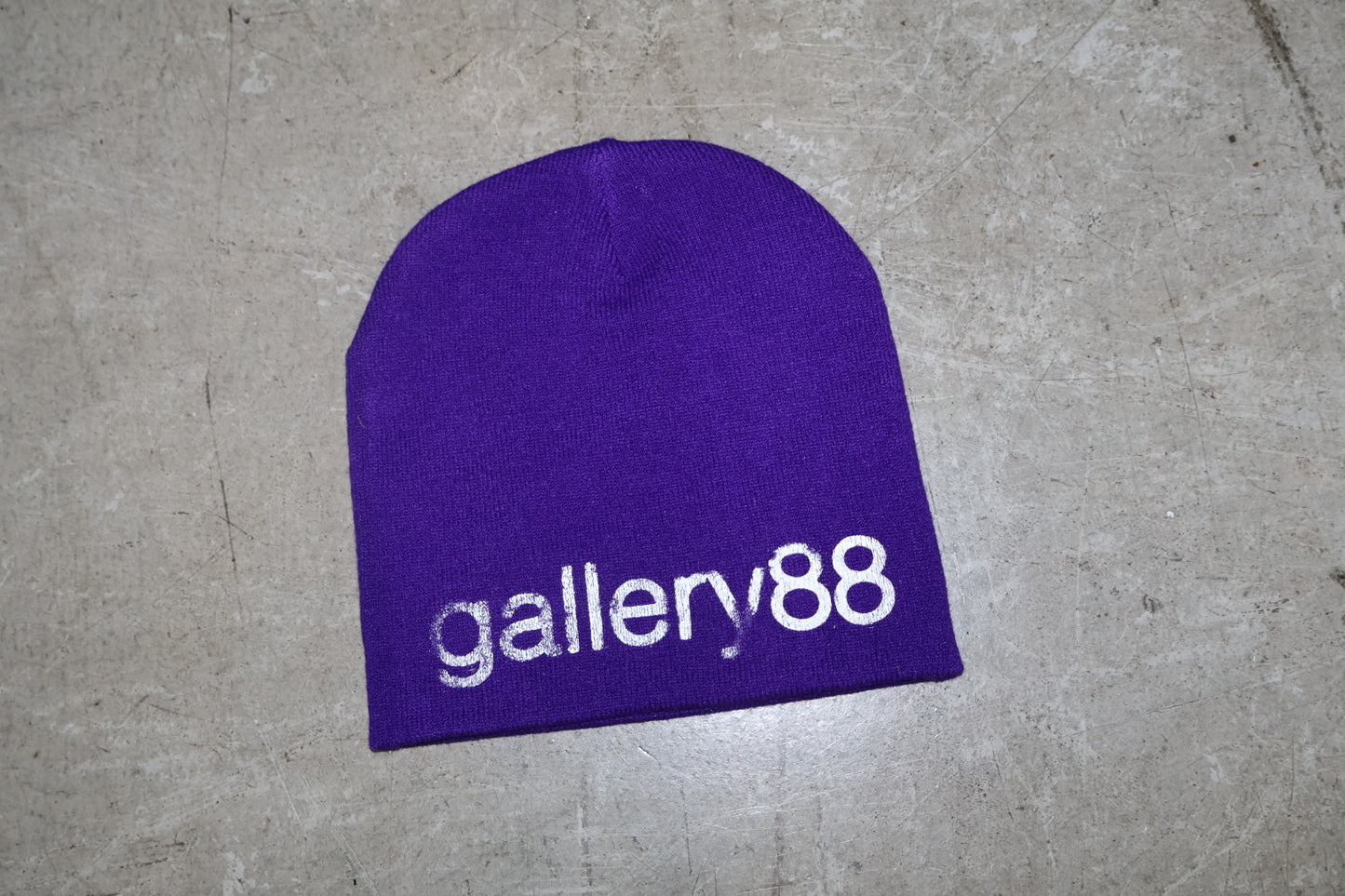 Purple beanie with 'gallery88' logo on a gray surface